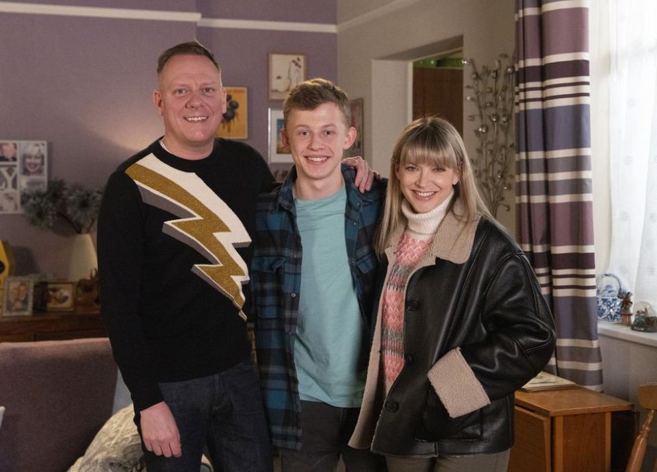 a man wearing a lightning bolt sweater is standing next to a woman and a boy