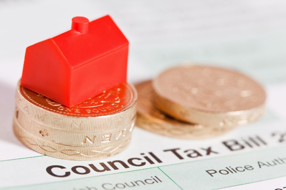 a stack of coins on top of a council tax bill