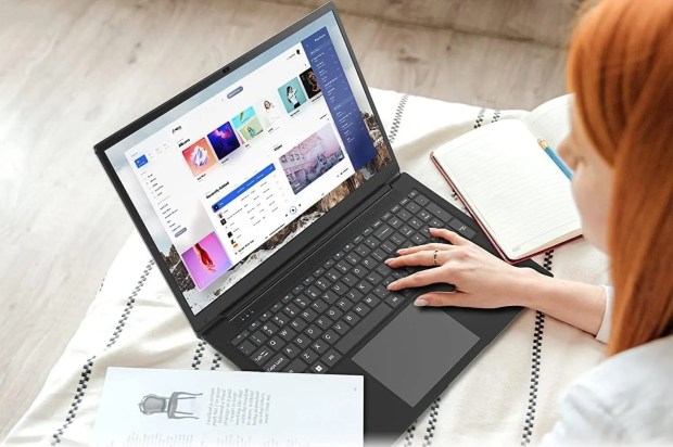 a woman is using a laptop with a playlist on the screen