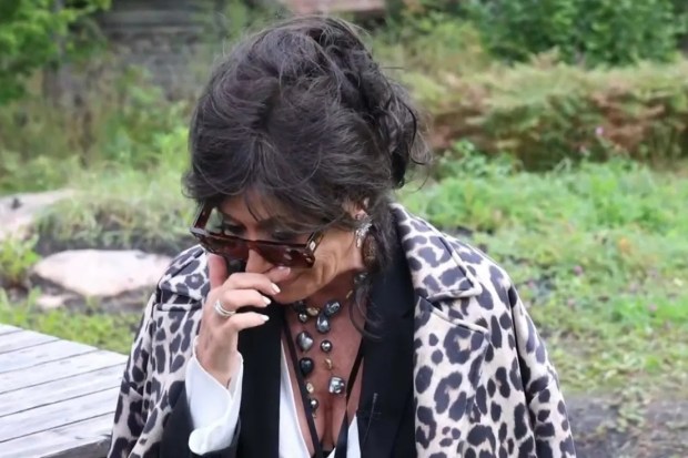 a woman wearing a leopard print coat is talking on a cell phone