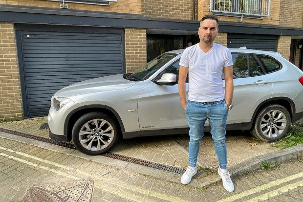 a man is standing in front of a white bmw