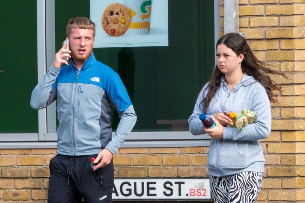 a man and a woman are walking down ague street