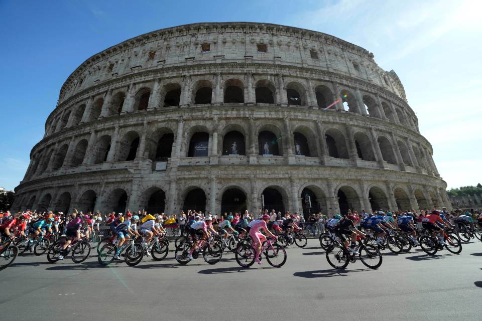 a group of cyclists are riding in front of the colosseum