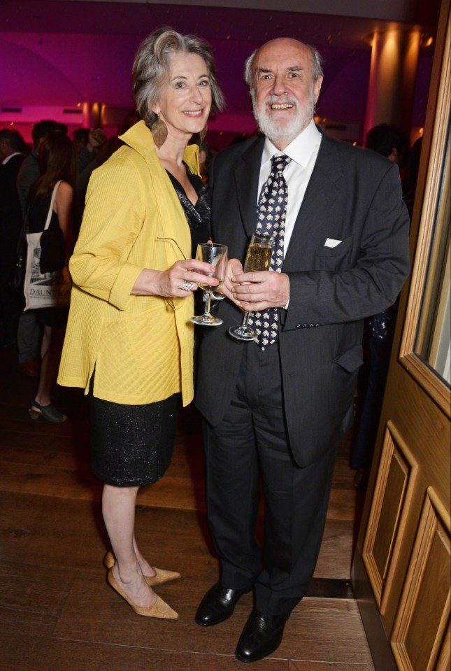 a man in a suit and tie stands next to a woman in a yellow jacket