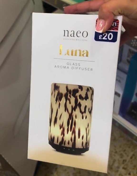 a woman is holding a naeo luna glass aroma diffuser