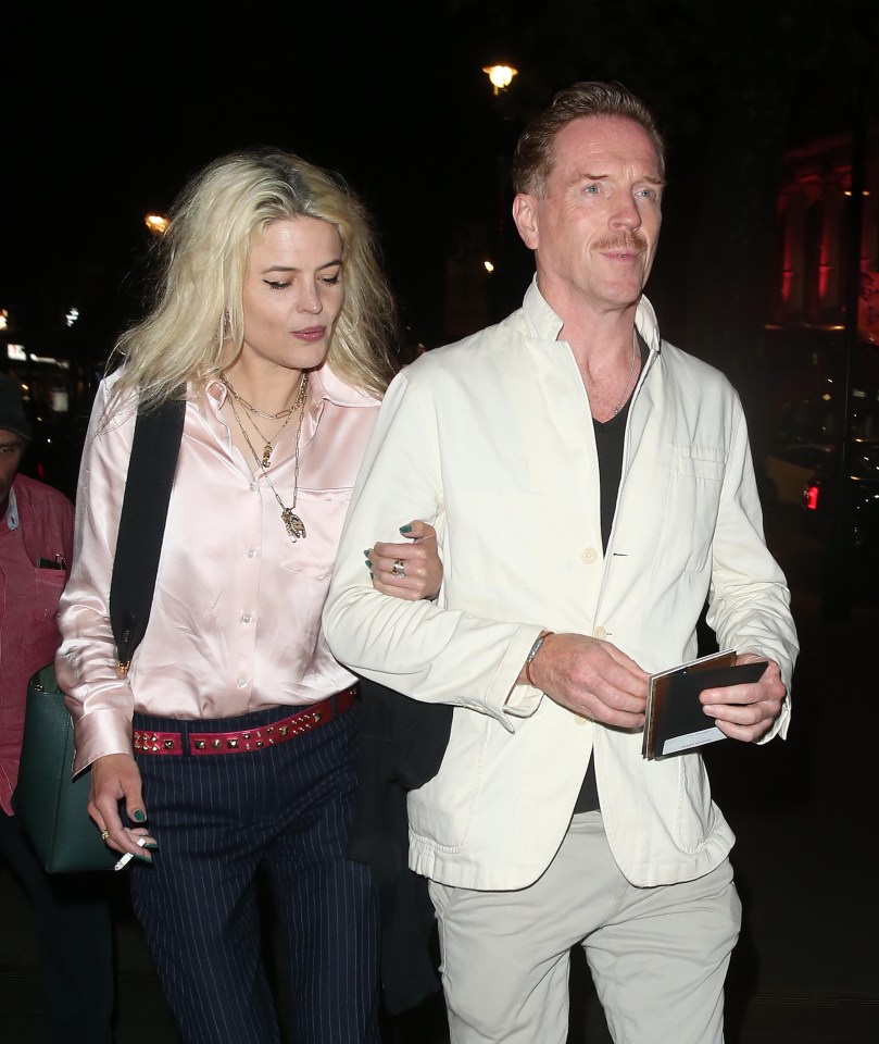 a man and a woman are walking down a street at night