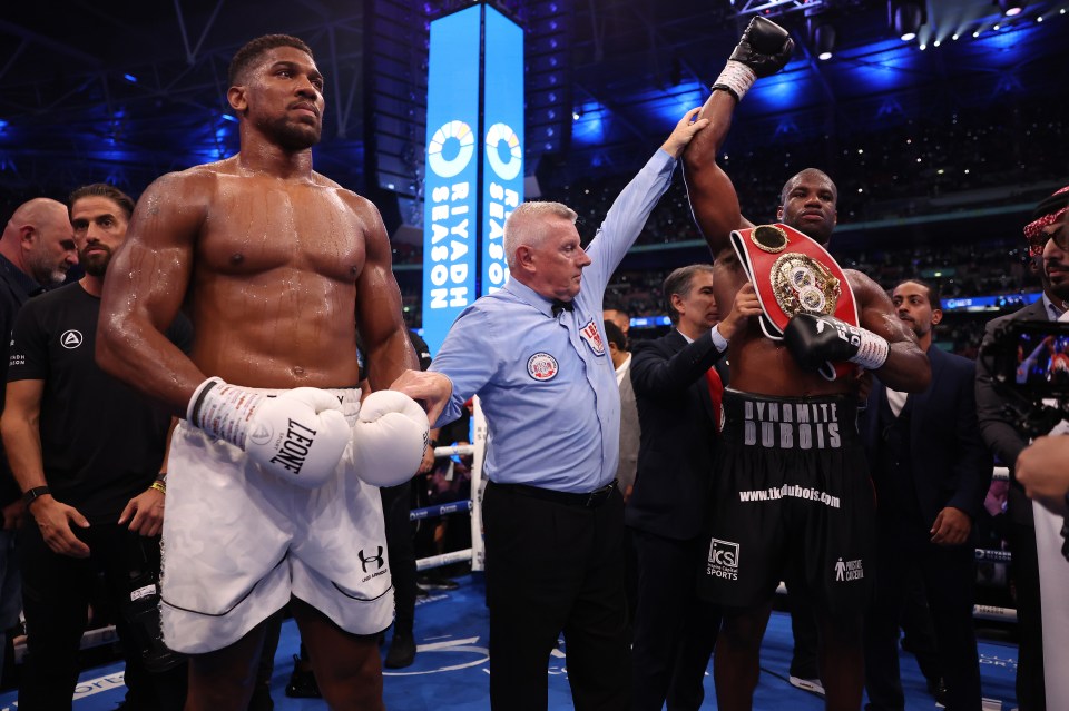 a boxer wearing leone gloves stands next to another boxer