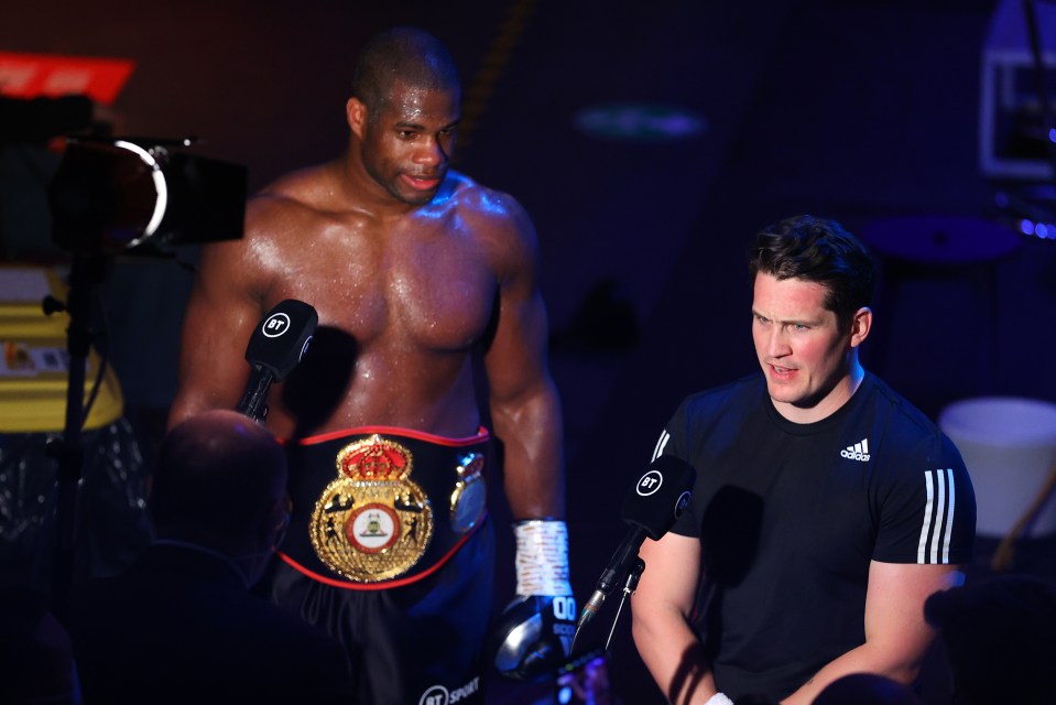 a man wearing an adidas shirt stands next to a boxer