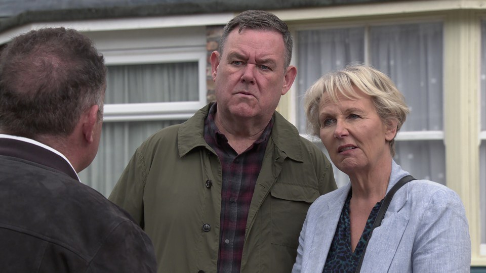 a man and a woman are standing in front of a house