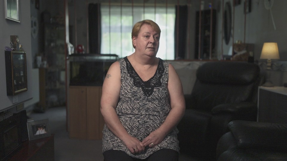 a woman with a tattoo on her arm sits in a living room