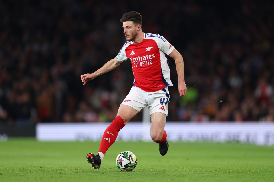 a soccer player wearing a red and white jersey that says emirates fly better