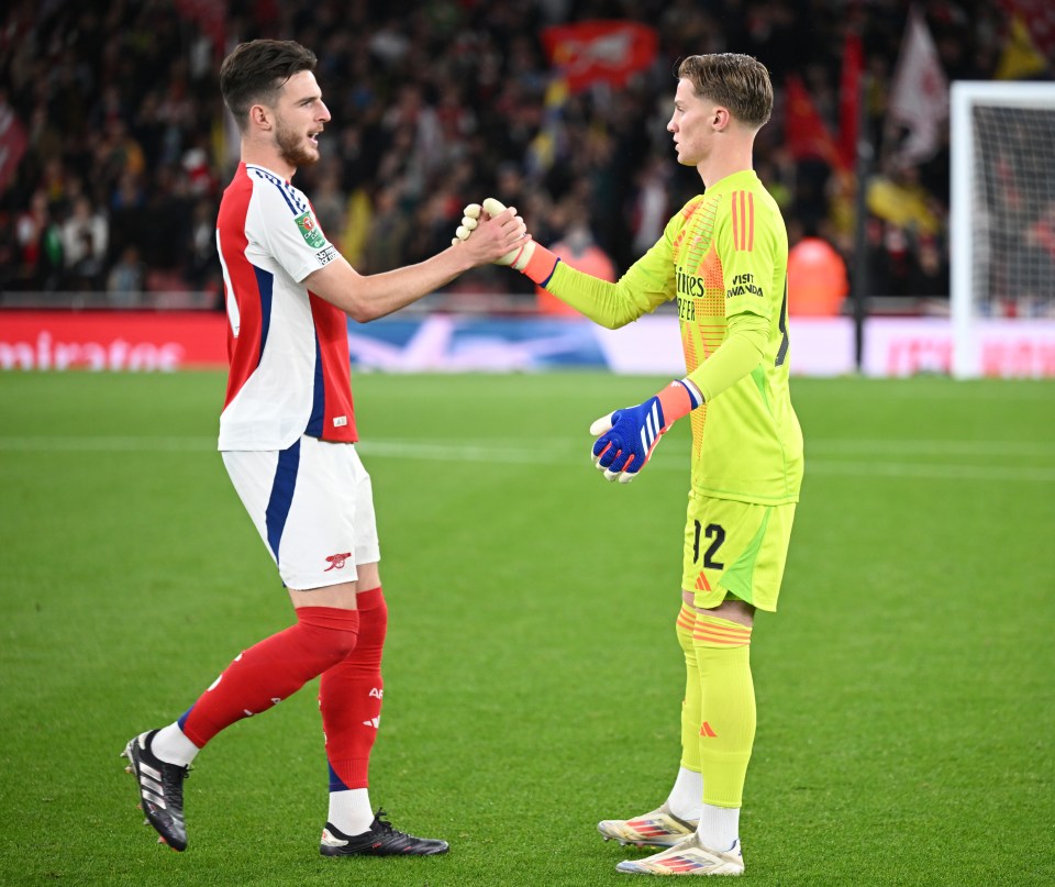 a soccer player with the number 12 on his jersey shakes hands with another player