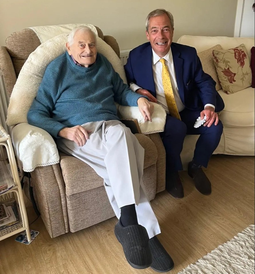 a man in a suit sits next to an older man in a chair