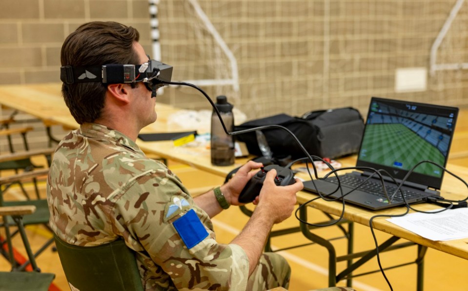 A Paratrooper flies a simulated Aquila, Beta FPV (first person view), drone through a FPV virtual reality headset though a course of gates on a laptop