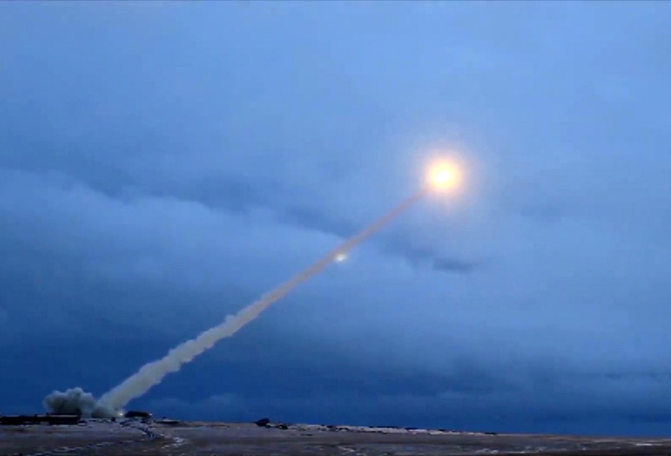 a rocket is flying through a cloudy blue sky