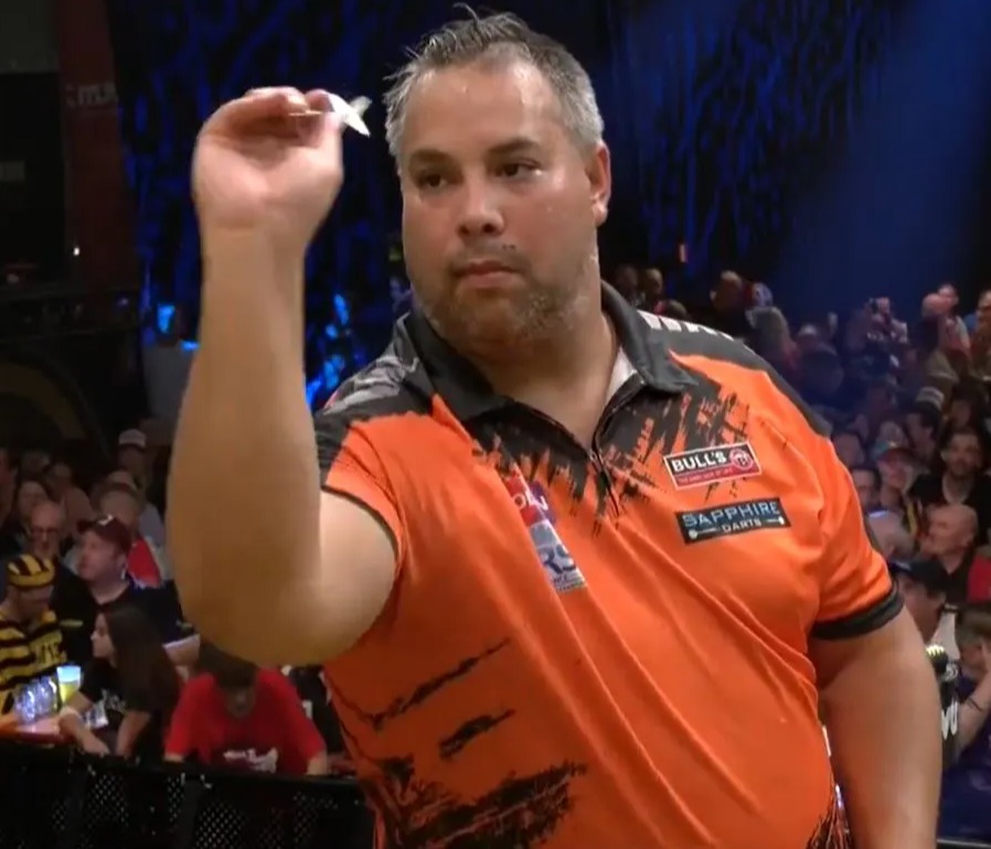 a man in an orange bulls jersey holds a dart in his hand