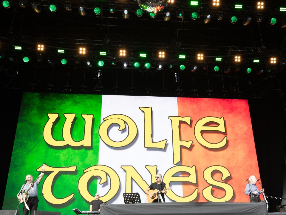 wolfe tones performing on stage with a large screen behind them