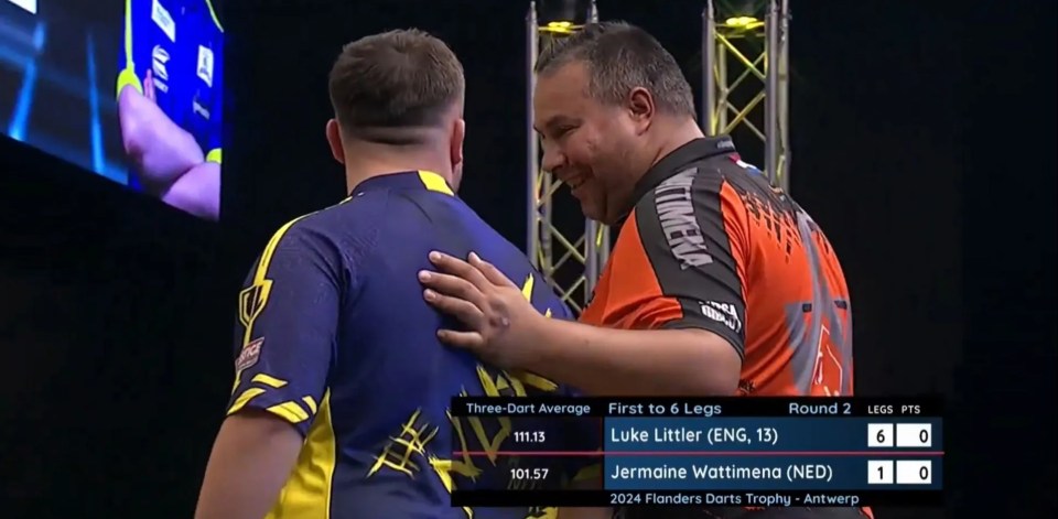 two men are hugging each other in front of a scoreboard that says first to 6 legs