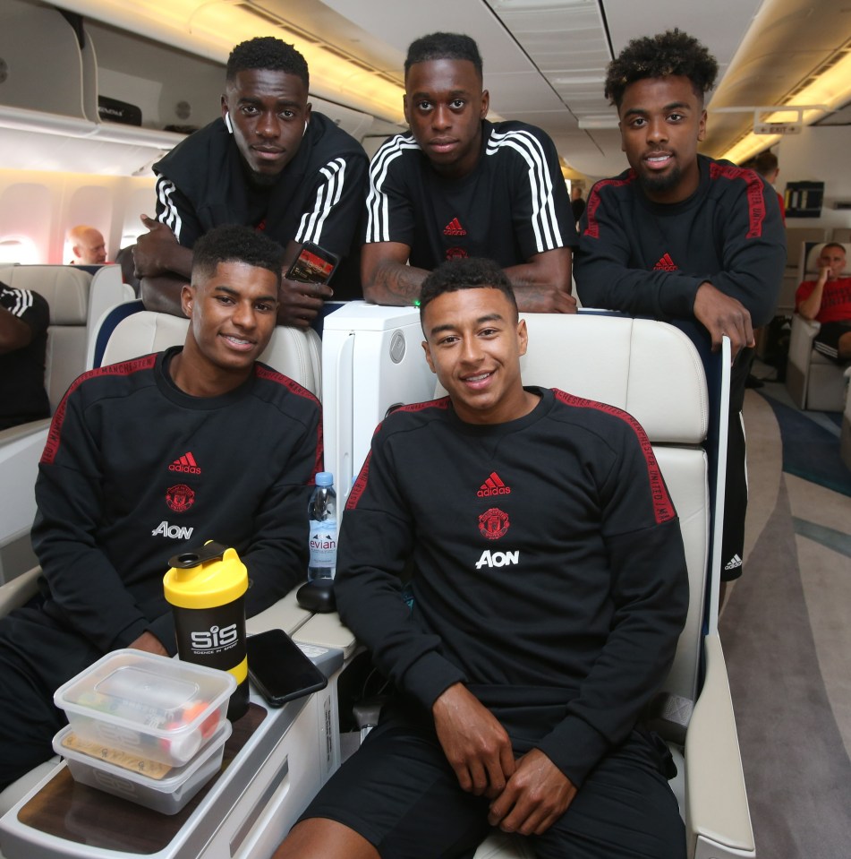 a group of young men are sitting on an airplane wearing adidas shirts