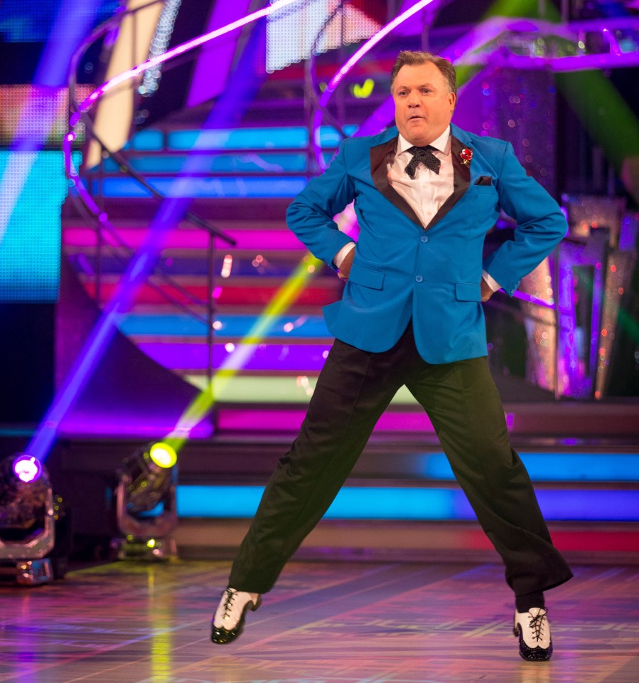 a man in a blue suit is dancing on a stage