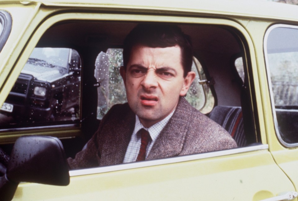 a man in a suit and tie is sitting in a yellow car