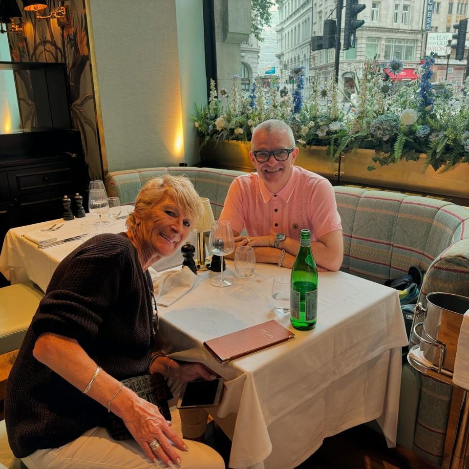 a man and woman sit at a table with a menu on it