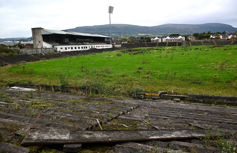 a picture of a field with a stadium in the background