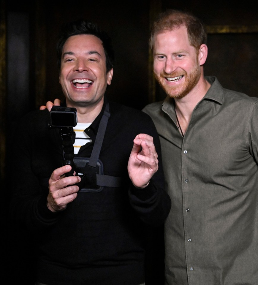 two men are posing for a picture and one is holding a camera