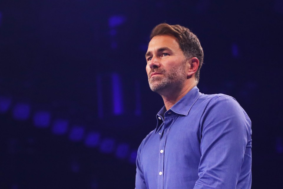 a man in a blue shirt stands in front of a blue background