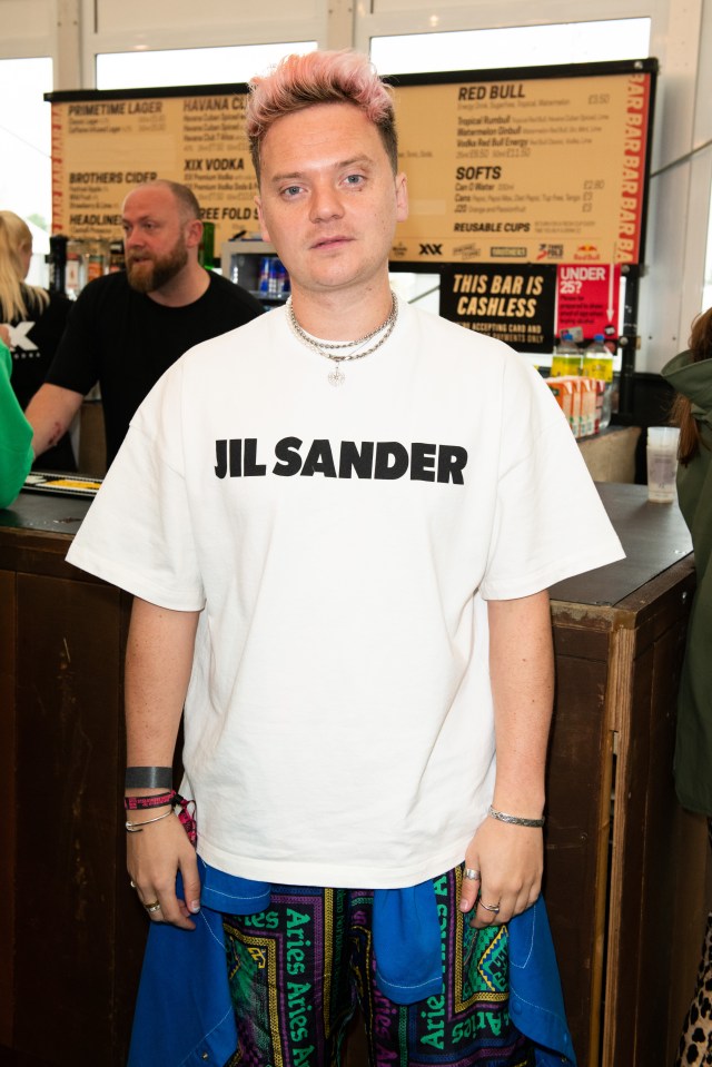 a man with pink hair is wearing a jil sander shirt