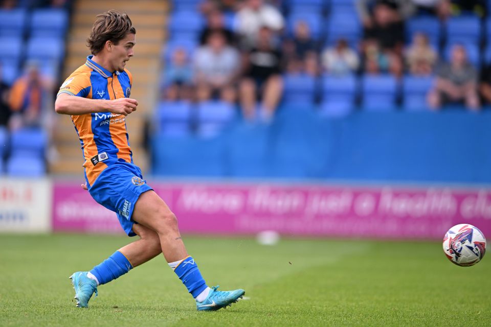 a soccer player wearing a blue and orange jersey that says mc on it