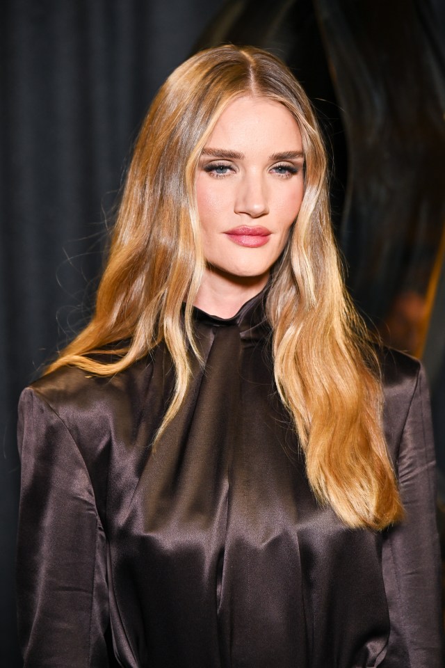 a woman with long blonde hair is wearing a black satin top