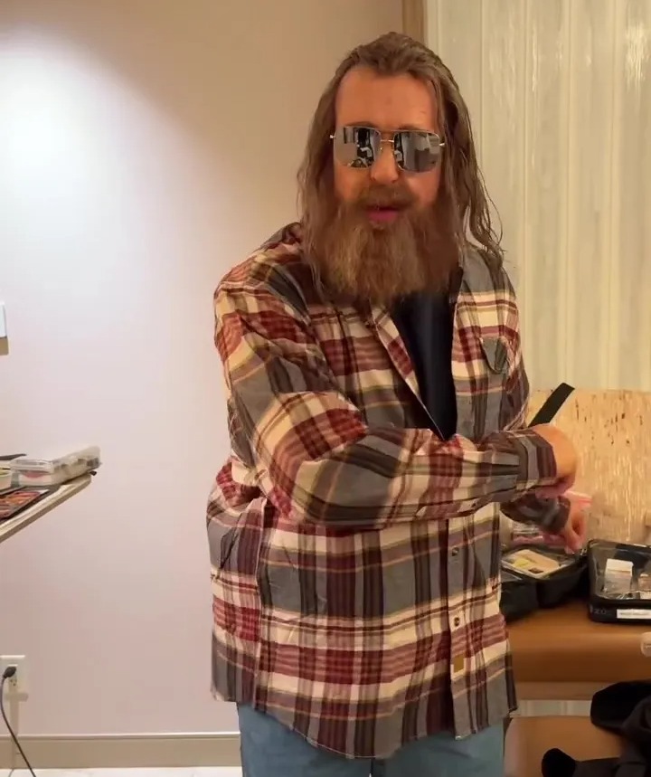 a man with a beard wearing sunglasses and a plaid shirt