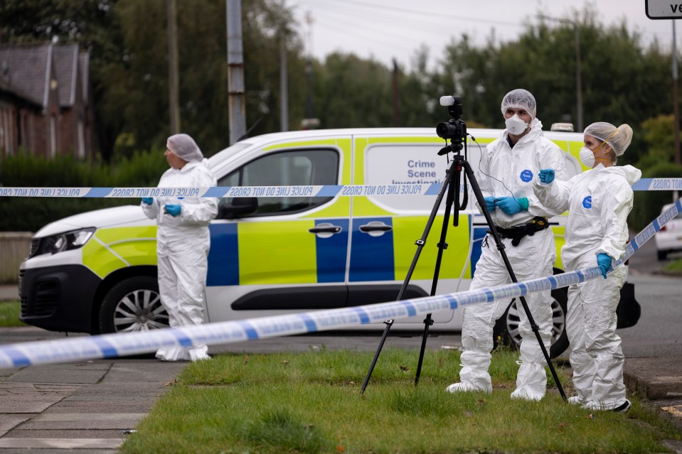 Forensics officers at the scene in Salford