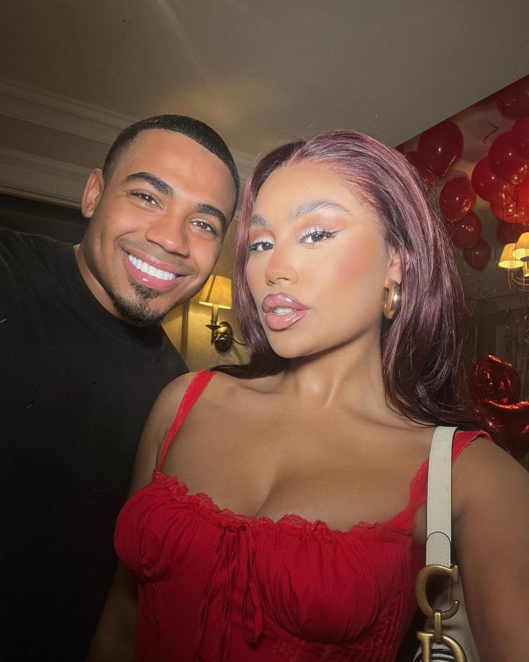 a man and a woman pose for a picture with balloons in the background