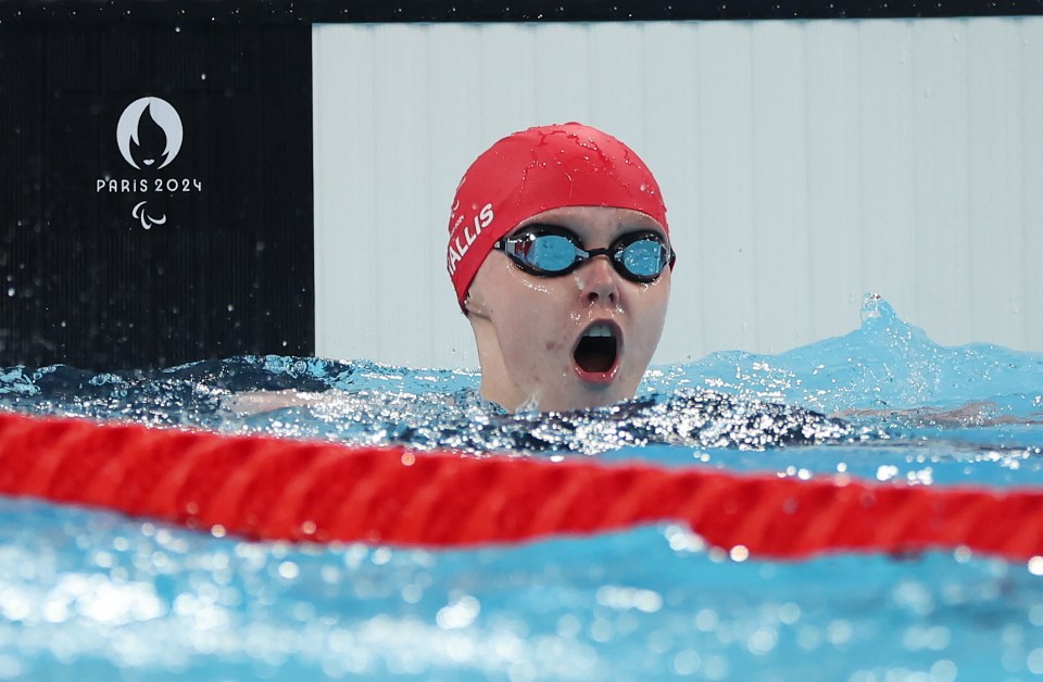 a female swimmer wearing a red cap with the word allis on it