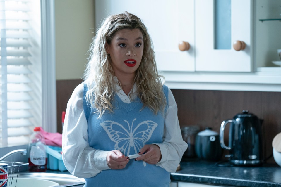 a woman wearing a blue vest with a butterfly on it