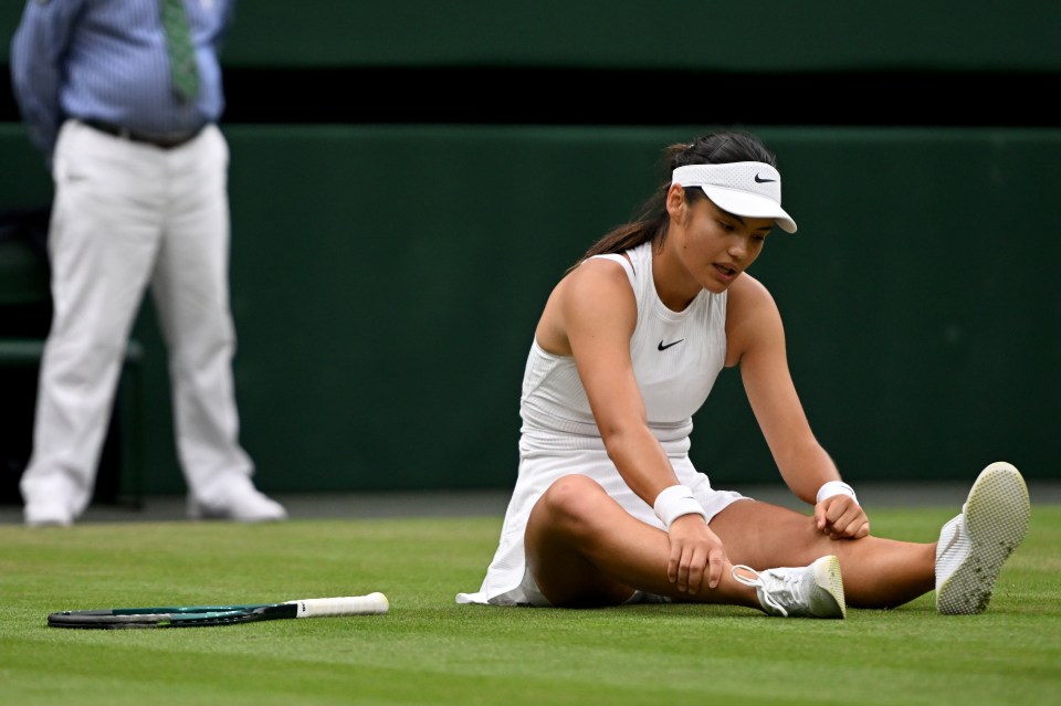 a woman wearing a nike visor sits on the tennis court