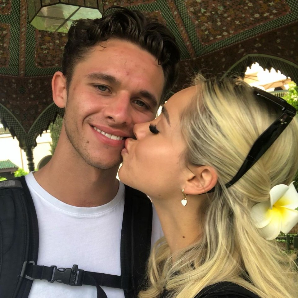 a woman kisses a man on the cheek in front of a gazebo