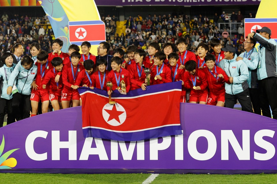 a group of soccer players holding a flag with the word champions on it