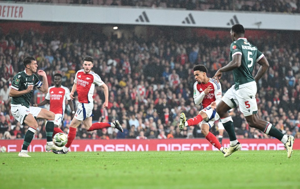 soccer players on a field with a sign that says arsenal direct