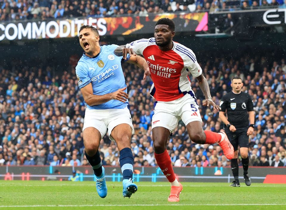 two soccer players on a field with one wearing a jersey that says emirates fly better