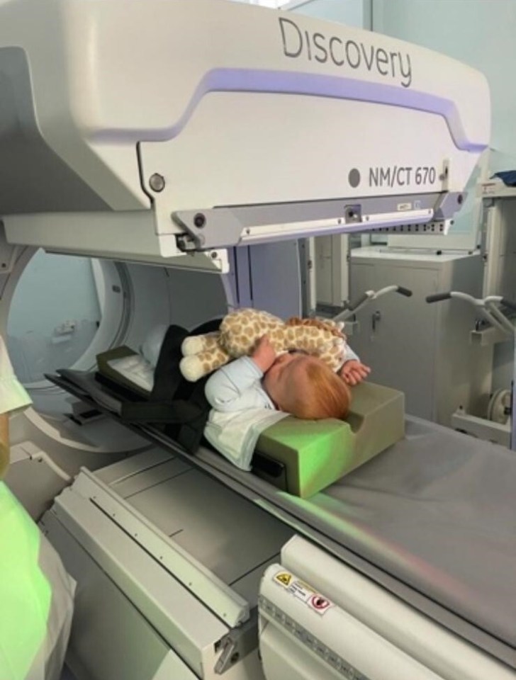 Carter having scans in hospital while holding his cuddly giraffe