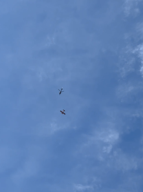 two small planes are flying in a blue sky