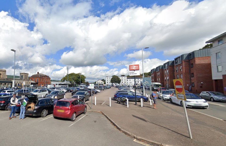 a parking lot with a sign that says ' railway station ' on it