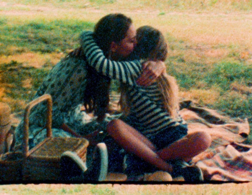 a woman kisses a little girl on the cheek