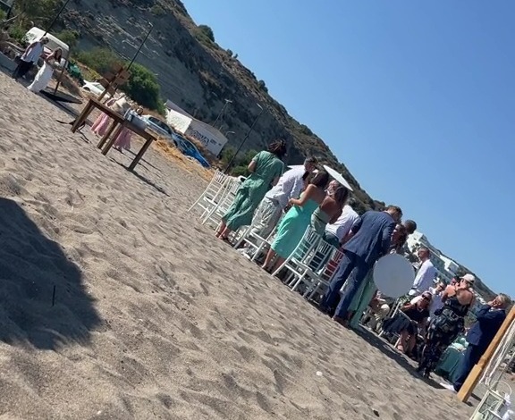 a group of people are gathered on a sandy beach