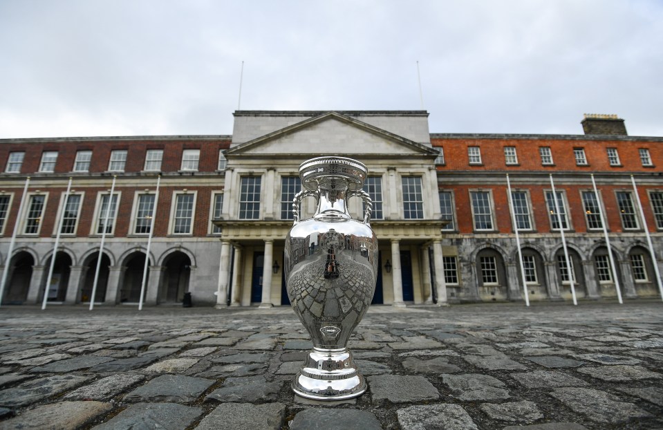 a silver vase is in front of a brick building