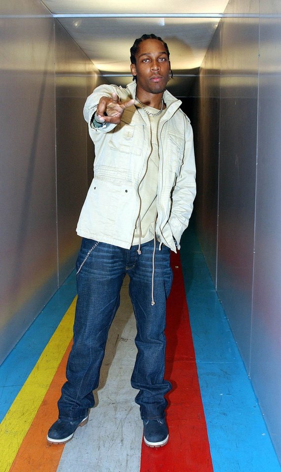 a man in a white jacket stands in a colorful tunnel