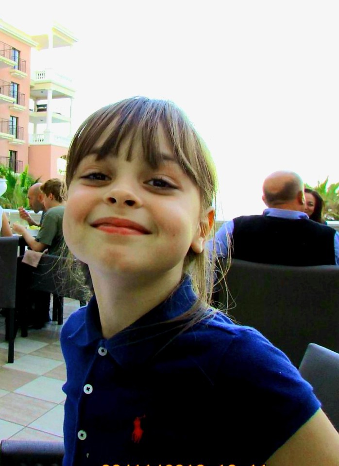 a little girl wearing a blue polo shirt with a red horse on it